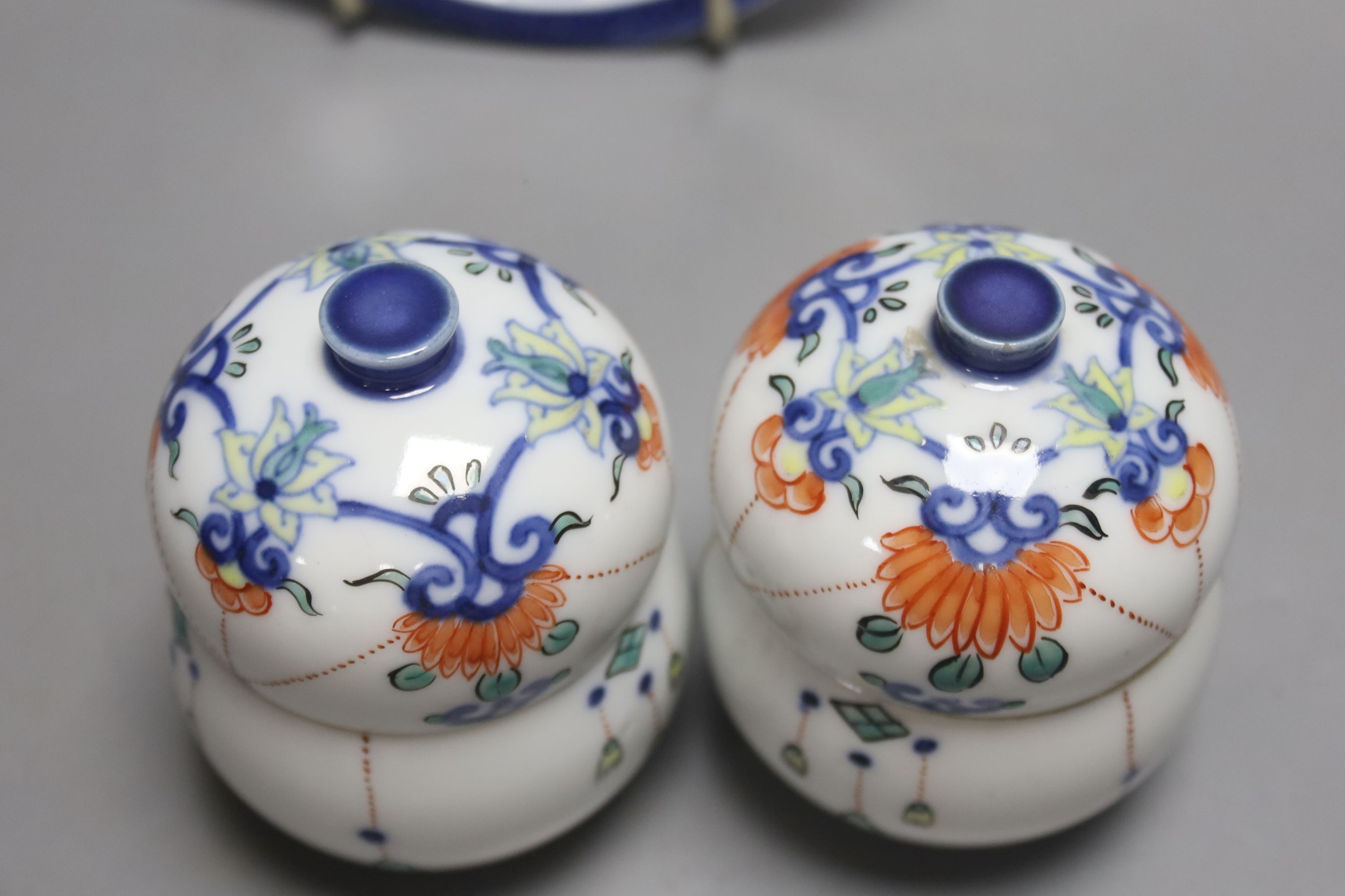 A pair of Japanese Nabeshima style jars and covers and a similar footed dish, tallest 9cm